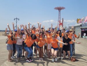 INCLUDEnyc team wearing orange t-shirts on Coney Island boardwalk